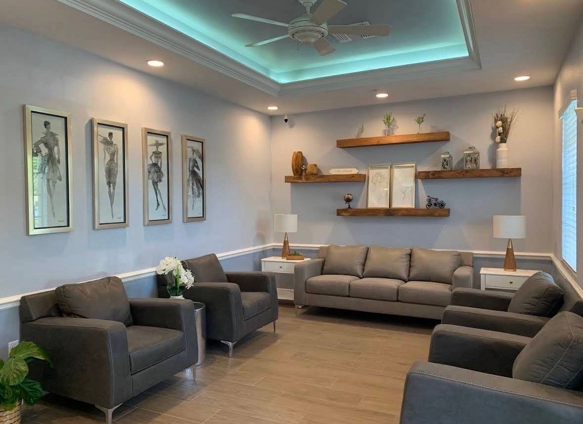 Coastal-inspired lounge with soft grey seating and teal ceiling glow
