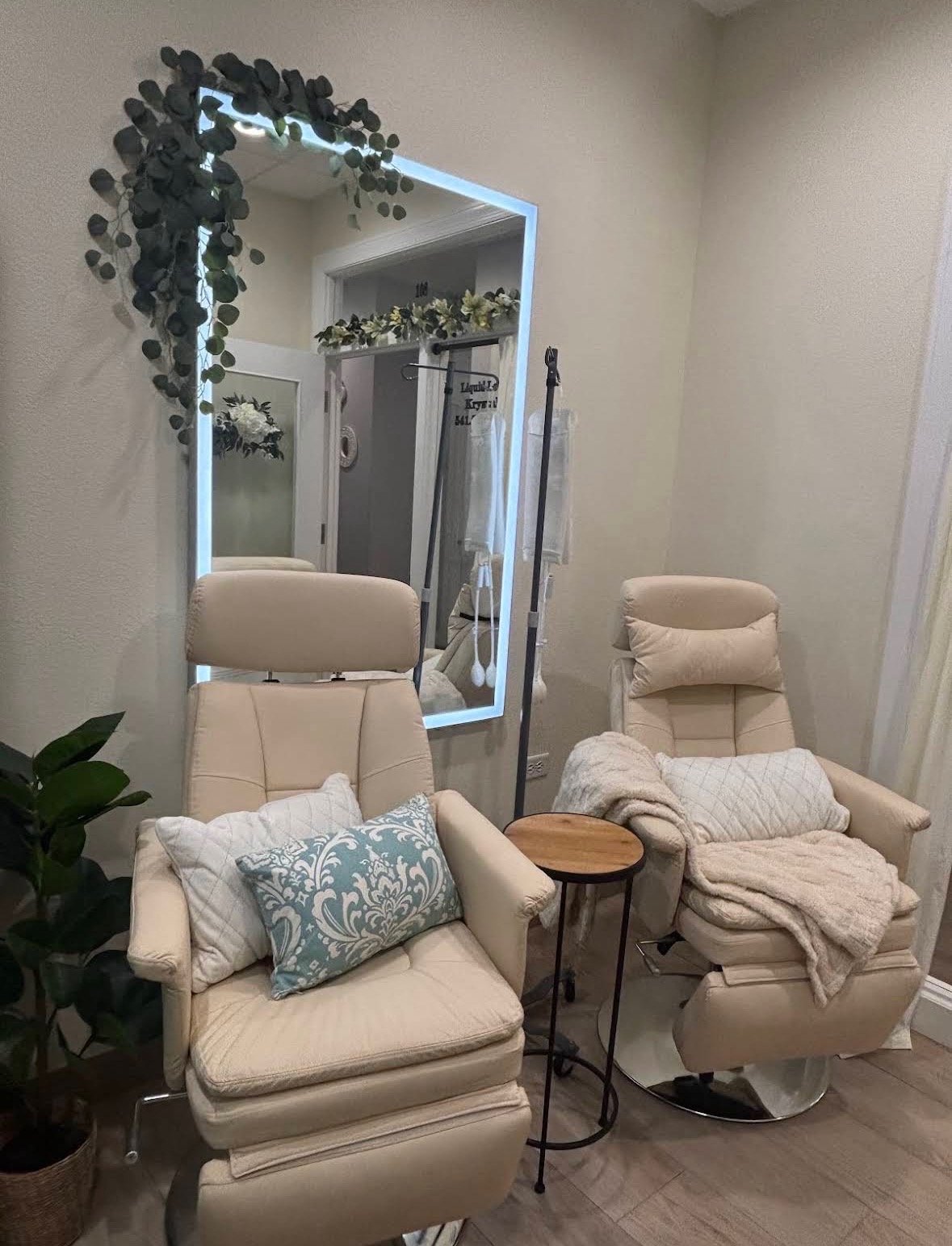 Cozy cream recliners with throw blankets and a lit mirror